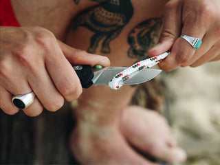 A man slicing through rope with his Carter EDC folding pocket knife.