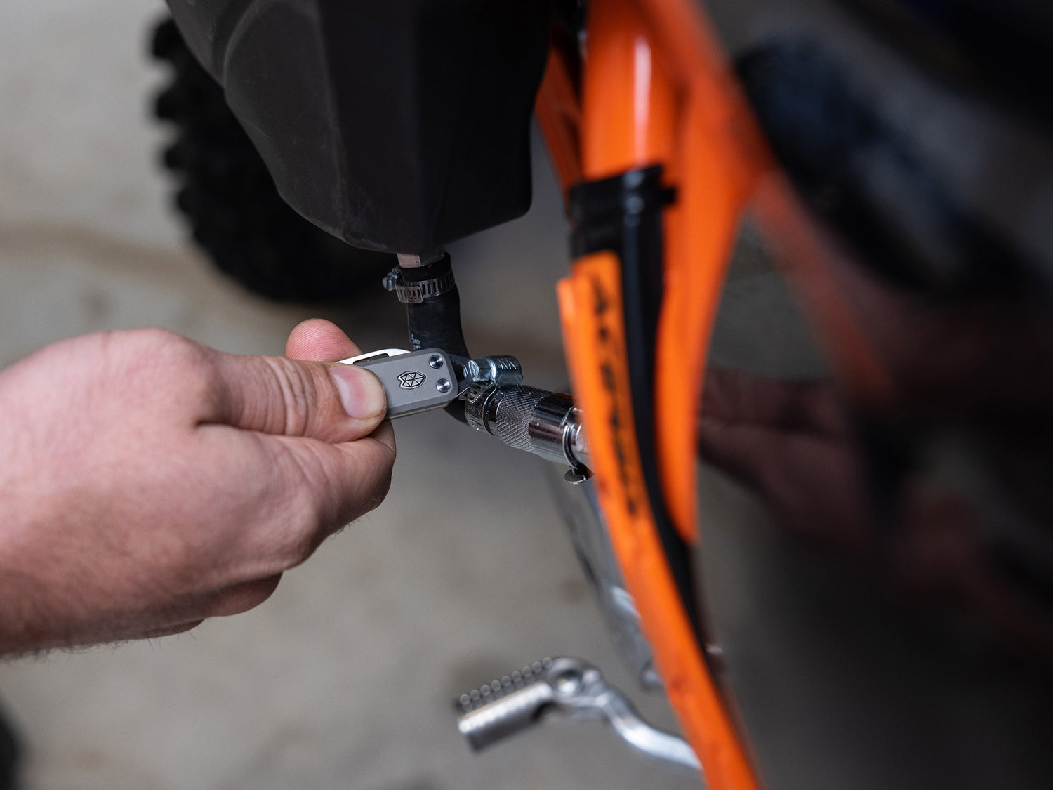 A man repairing his motorcycle with an Elko EDC keychain slip joint folding pocket knife.