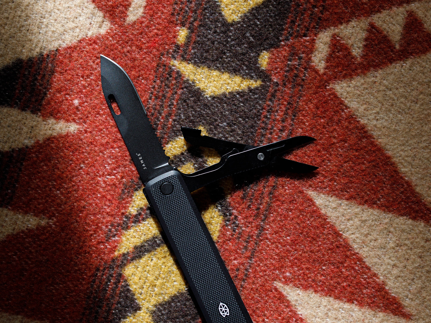 The scissors of the Ellis EDC multitool pocket knife on a Mexican blanket.