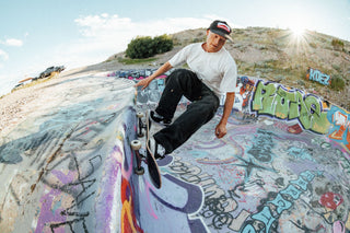 A skateboarder banking off the top of a pool.