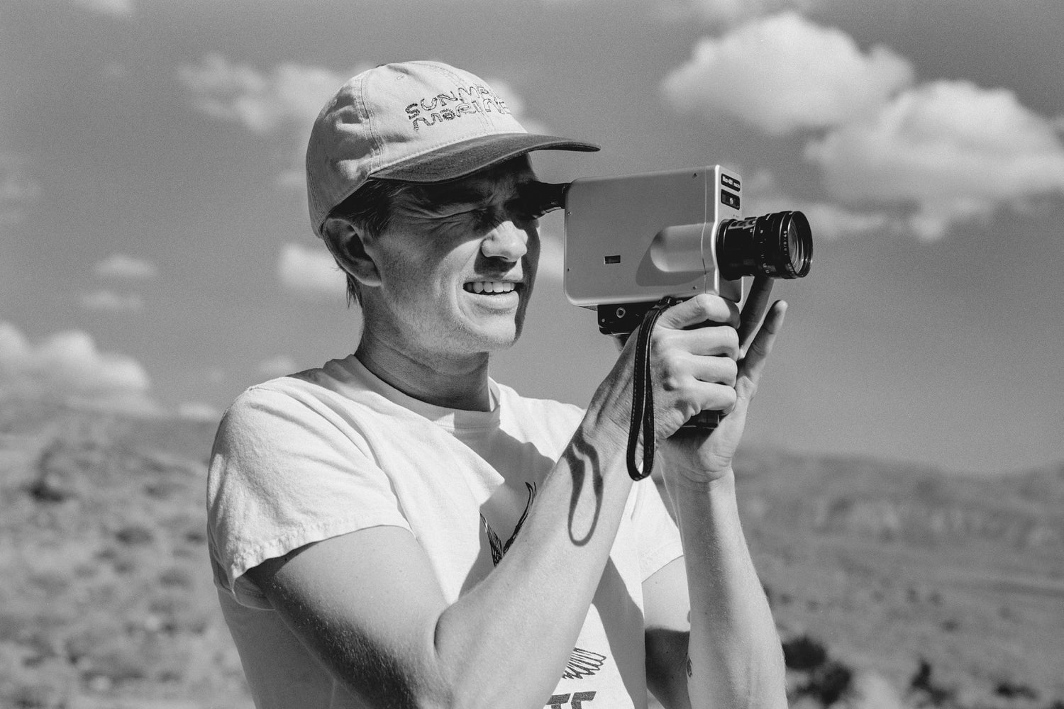 A man filming with a Super 8 camera.