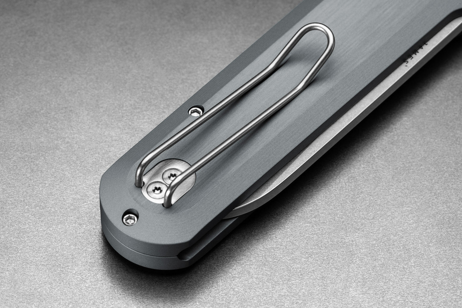 The pocket clip of the made in the USA Wells EDC button lock folding pocket knife in raw aluminum and Magnacut steel.