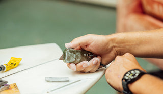 A person repairing his surfboard with the Palmer utility box cutter knife.