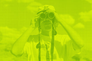A green graphic with a man with binoculars.