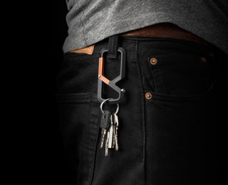 The Mehlville EDC keychain carabiner with Carryology branding attached to a belt loop.