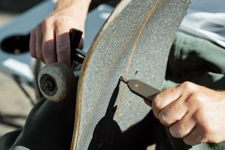 The Warrick EDC screwdriver being used to tighten trucks to a skateboard.