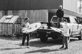 Three guys loading up a truck with surfboards in Nova Scotia.