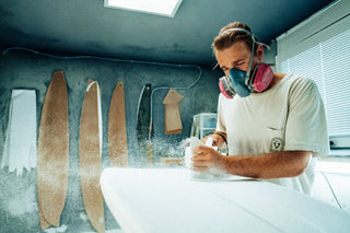 A man shaping a surfboard in Nova Scotia, Canada.