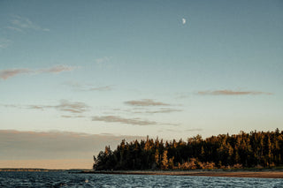 Sunset over a forest covered coast in Nova Scotia.