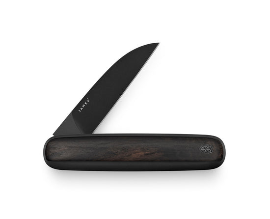 The ebony Pike pocket knife on a steel surface.