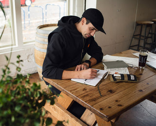 The man sketching with Burwell EDC twist pen in black at a table.