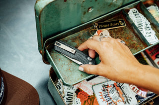 A women placing her carbon fiber Carter EDC slide lock folding pocket knife into a tool box.