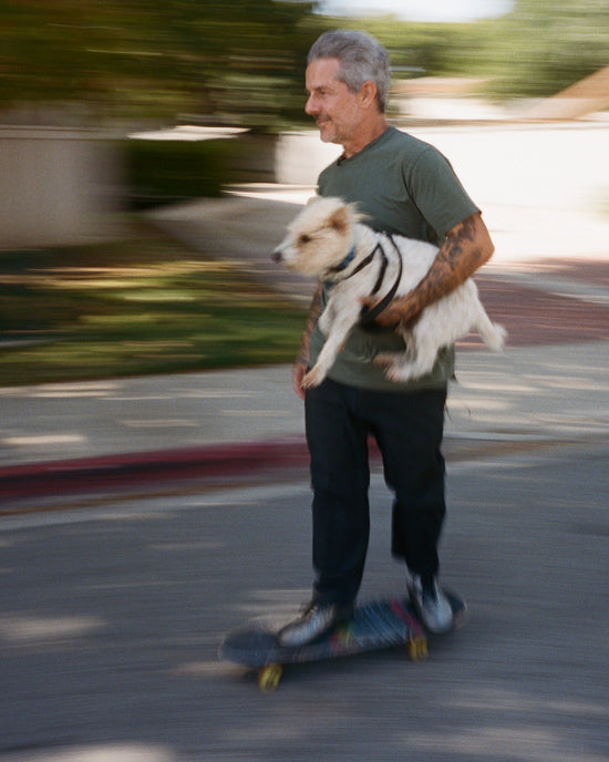 Mark Oblow skateboarding with his dog.