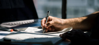 A person sketching with the Kent bolt-action pen.