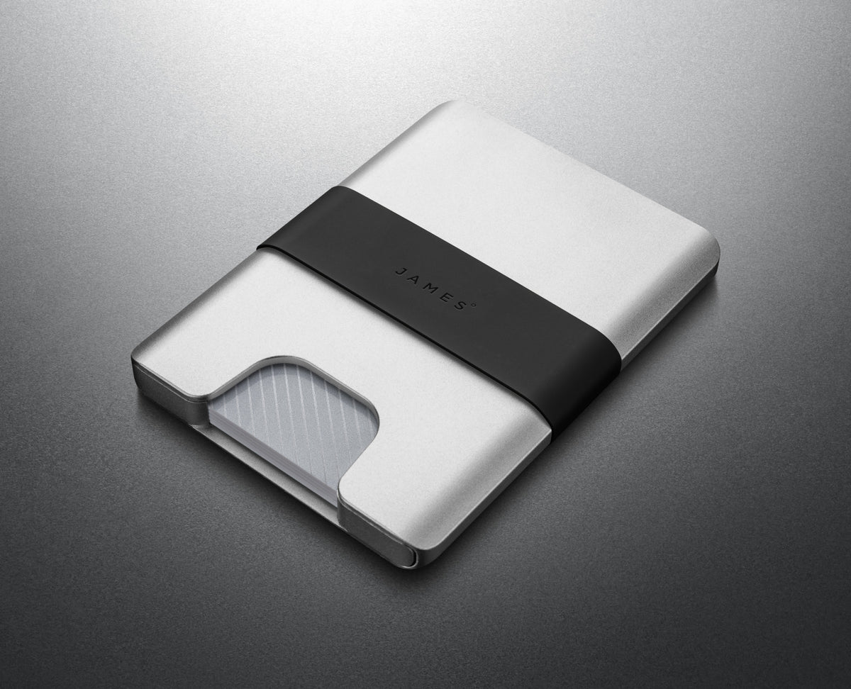 The Lowe minimalist card holder wallet in silver and black on a steel background.