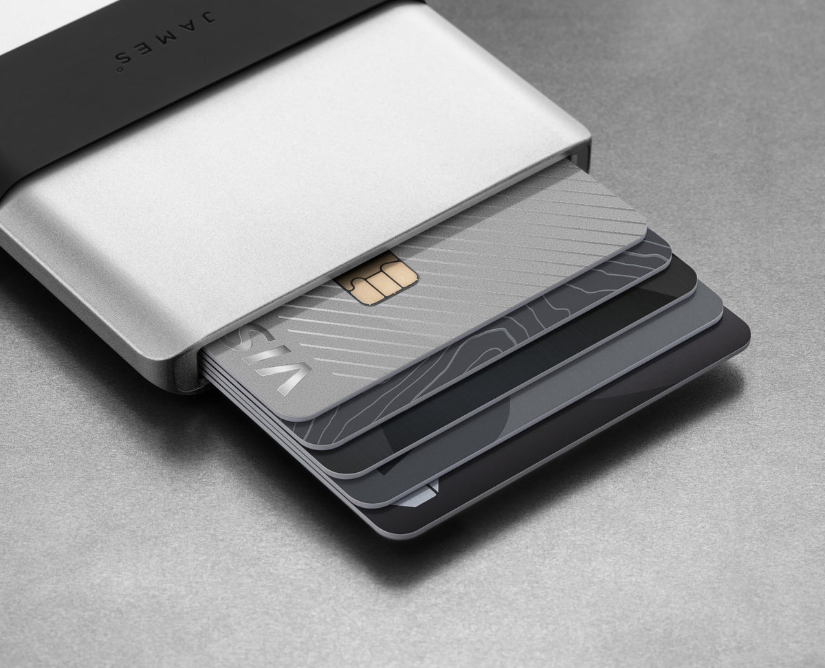 Credit cards fanning from The Lowe minimalist card holder wallet in silver and black.