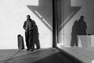 Beatrice Domond posing next to her skateboard. 