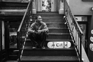 Professional skateboarder Beatrice Domond sitting on the steps of a building in New York.