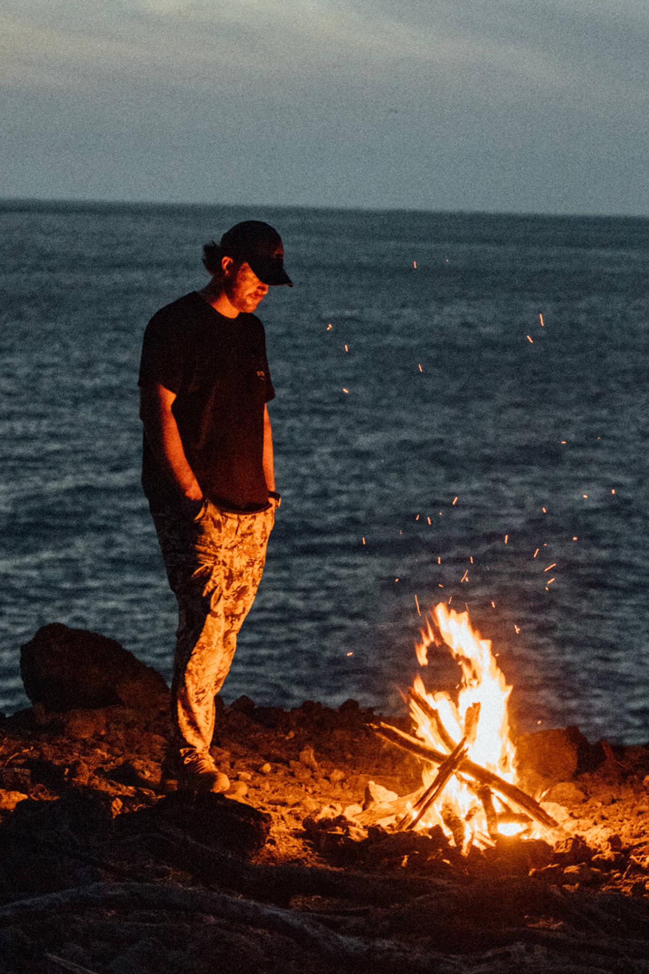 Chef Connor Gabbot on the coast next to a bonfire.