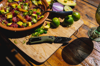 A bowl of ceviche with the Carter EDC pocket knife on a cutting board.
