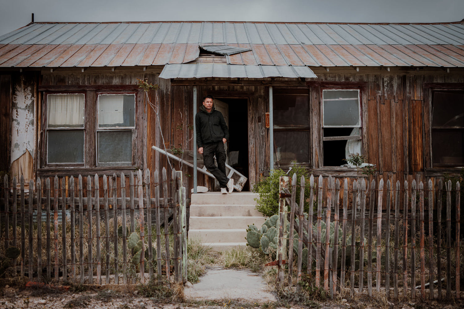 Josh Rosen standing in the doorway of an abandoned house.