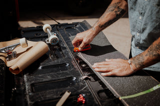 Josh Rosen setting up the grip tape on his skateboard.