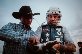 Josh Rosen getting help prepping to ride a bull.